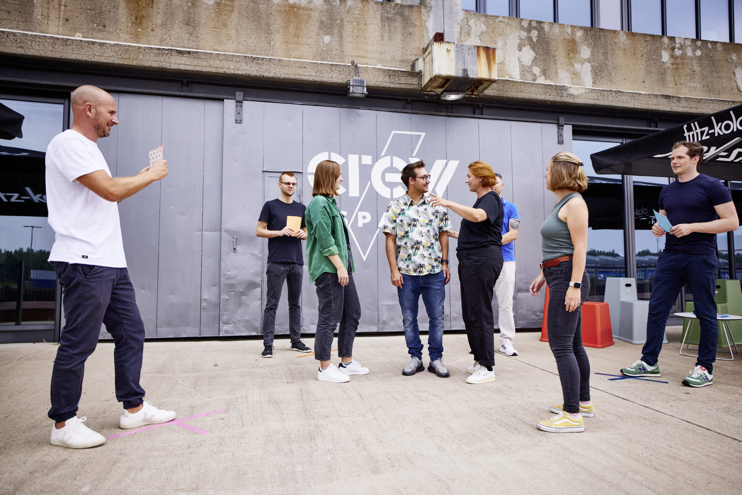 Mehrere Personen auf einer Terrasse im Freien, die versuchen, Teams zu bilden.