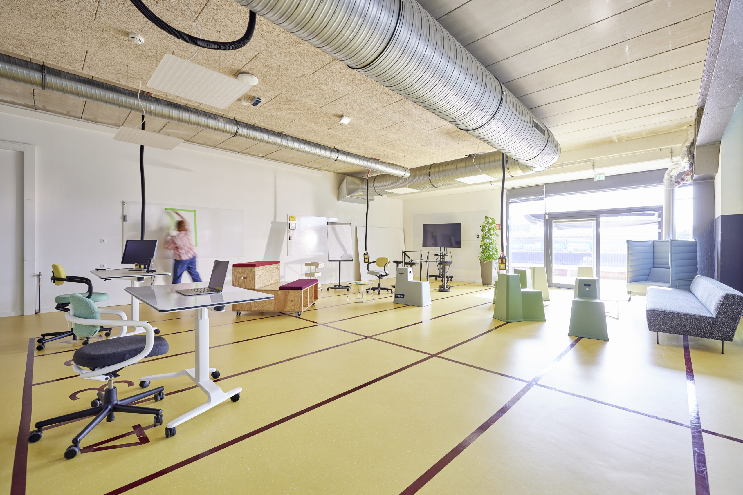 Moderner Workshopraum: Eine Person klebt etwas an ein Whiteboard.