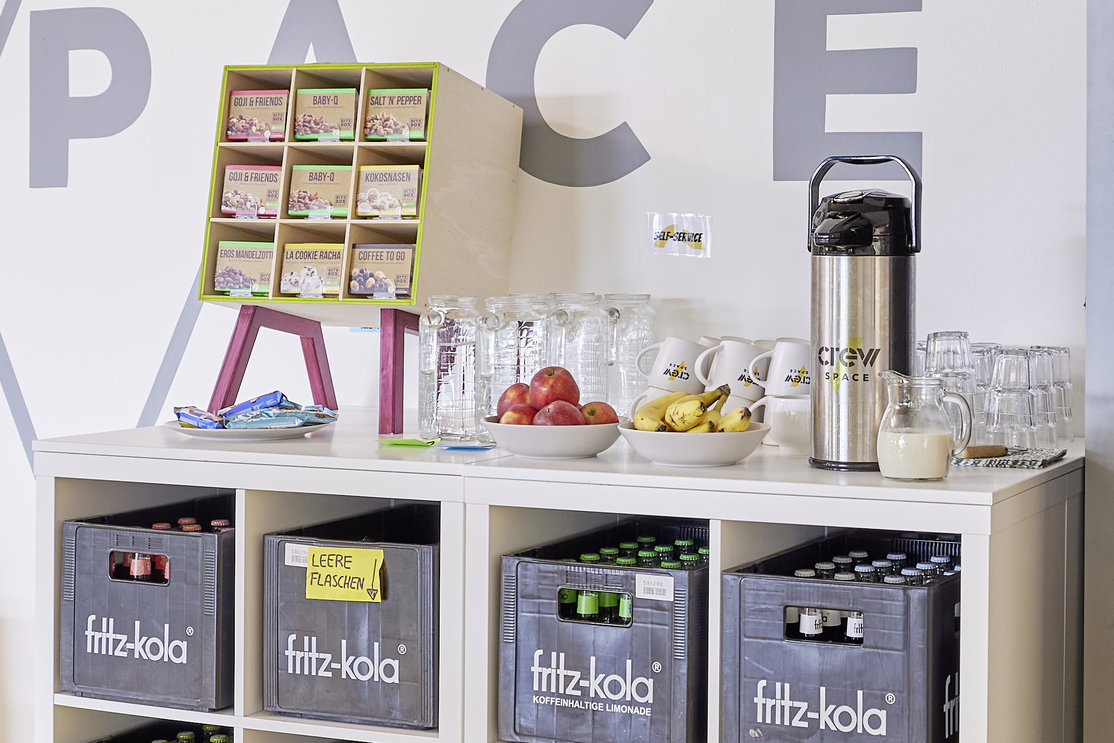 Gastro-Bereich im CREW Space mit Getränken, Kaffee, Obst und Snacks.